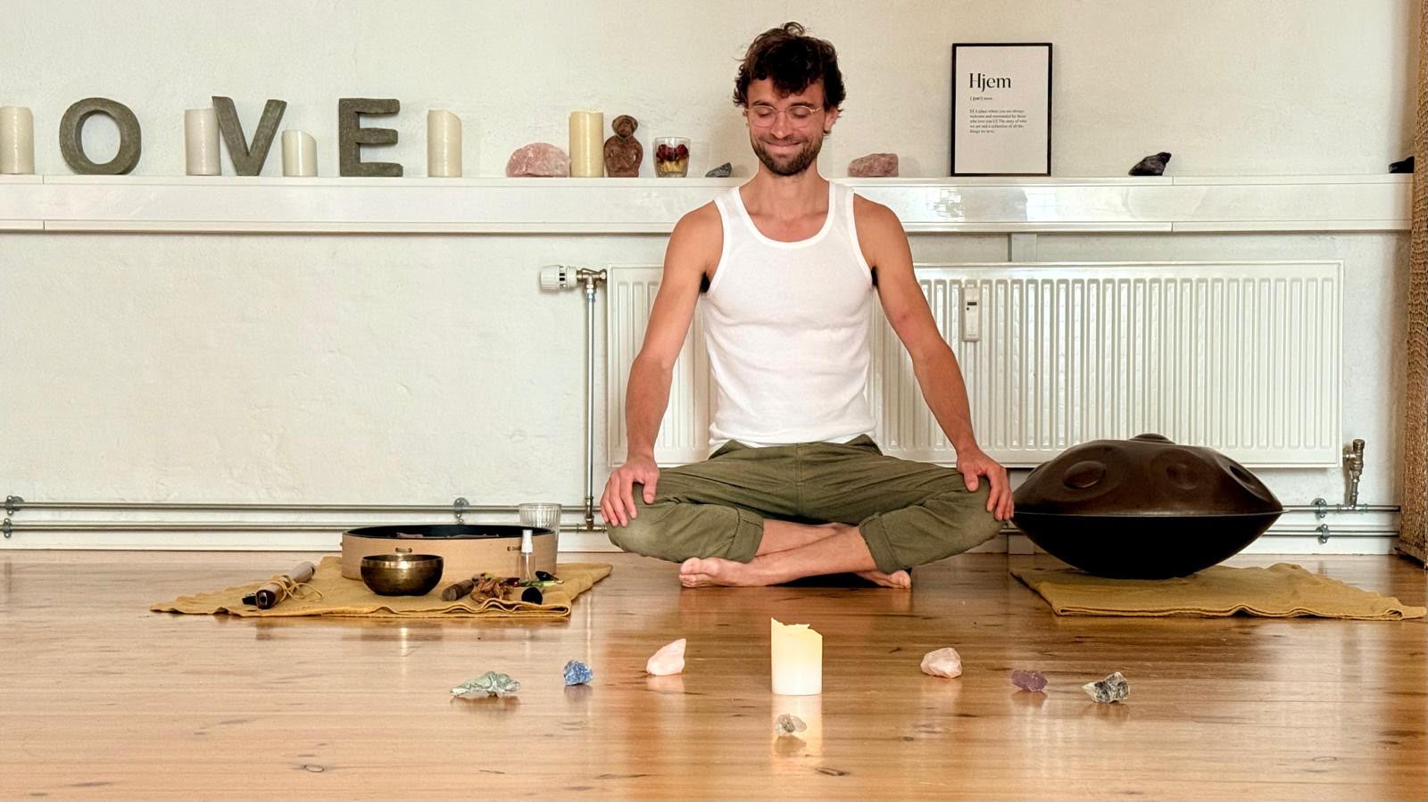Misha Talavera sitting in meditation with a handpan and singing bowl